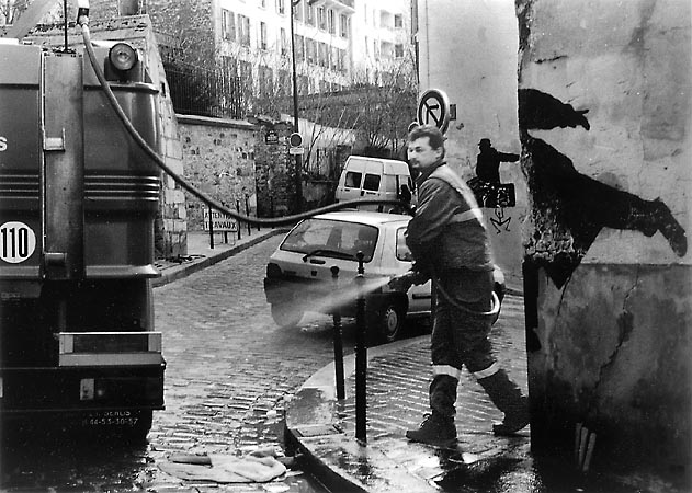 Un ouvrier municipal en train de nettoyer la rue des Cascades.