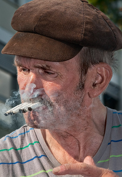 Claude Singeot en train de fumer cinq cigarettes devant le centre Pompidou.