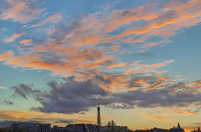 Pink and orange clouds over the Eiffel Tower at sunset.