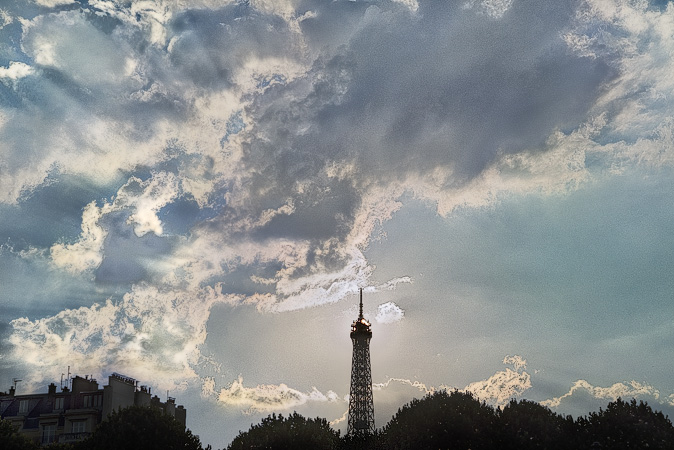 Le soleil juste derrière le dernier étage de la tour Eiffel.