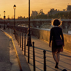 A young woman walking in to the sunset on île de la Cité.