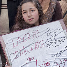Une fillette célébrant la démission de Hosni Moubarak avec une affiche: «Liberté, Démocratie aux peuples arabes».