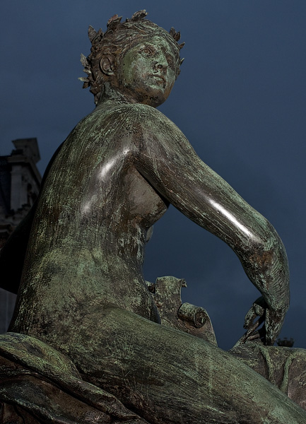 Une sculpture en bronze devant l’Hôtel de Ville le soir.