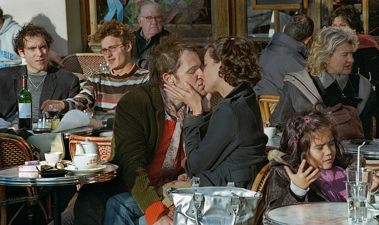 Un couple en train de s’embrasser sur sur la terrasse du café de l’île Saint-Louis.
