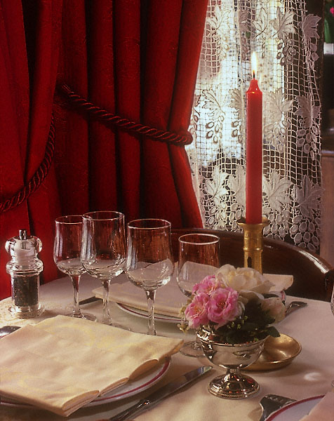 Des assiettes, verres, fleurs et une bougie sur une table au restaurant Léo le Lion.