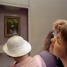 Museum visitors photographing the Mona Lisa in the musée du Louvre.