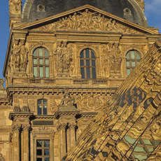 Le pavillon Richelieu du palais du Louvre reflété dans la pyramide de verre du musée au coucher du soleil.