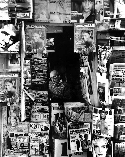 Un vendeur dans un kiosque à journaux sur le boulevard Montmartre.