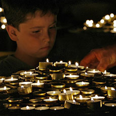 Un garçon avec des cierges à Notre-Dame.