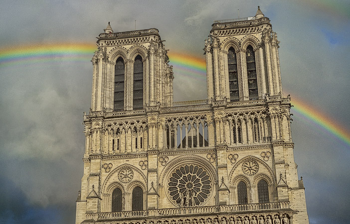 A rainbow passing behind the main façade of cathédrale Notre-Dame.
