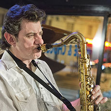 Un Américain joue du saxophone dans un café sur l’avenue de la République.
