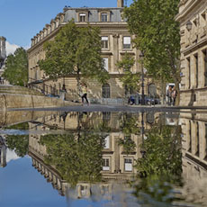 The caserne Napoléon and place Baudoyer reflected in a puddle on rue François-Miron.
