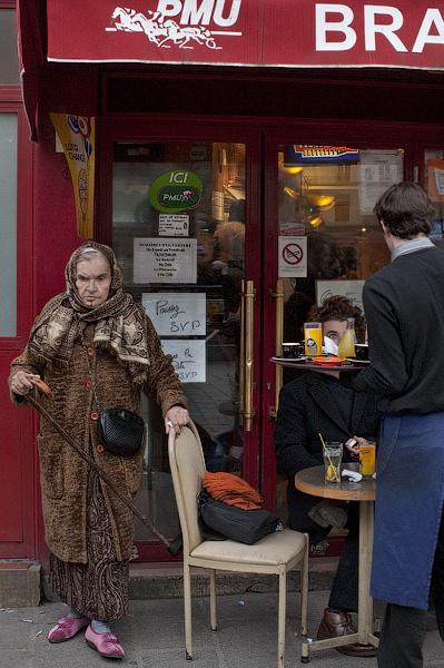 An elderly Algerian woman walking out of a tabac on rue Saint-Antoine.