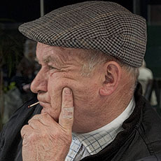 Un homme d’un certain âgé avec une allumette dans la bouche sur la rue de la Verrerie.