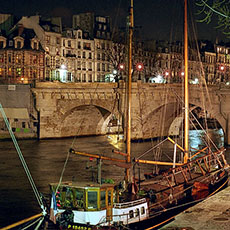 Boats on the Left Bank next to pont Neuf at night.