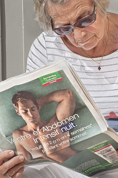 An older woman studying the back of a man in an advertising picture.