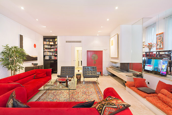 L’appartement est aménagé avec des meubles haute de gamme, y compris des chaises et canapés Roche Bobois, une table basse Mies van der Rohe, des tableaux originaux, des planchers de travertin, et des tapis orientaux.