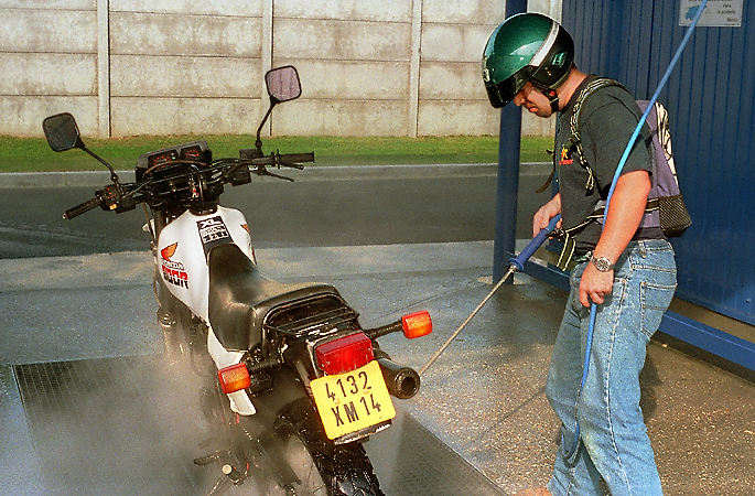 A man washing his motorcycle in Cabourg, France.