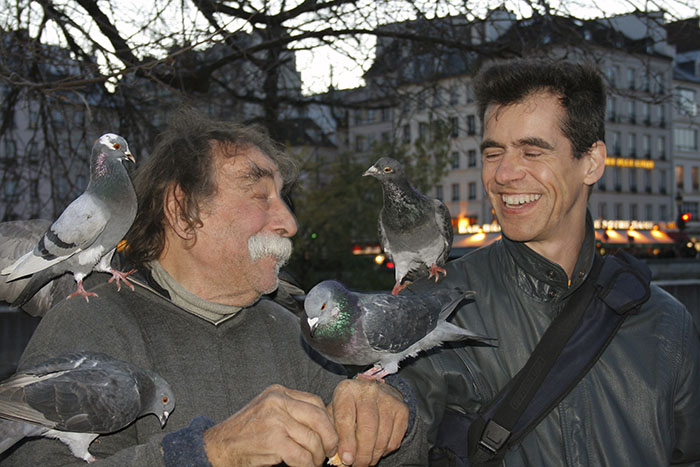 Pierre Pradeau et David Henry avec des pigeons devant Notre-Dame.