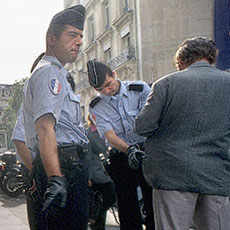 Two Parisian policemen interrogating and searching a man on rue la Boétie.