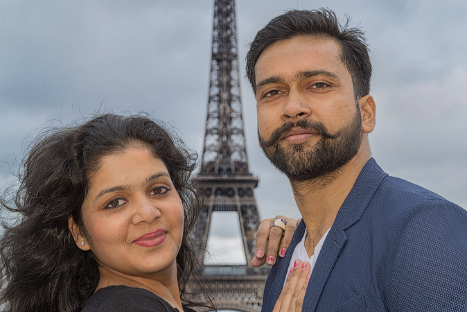 A portrait of Pulkit Goel and his wife in front of the Eiffel Tower.