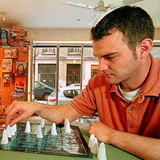 A couple of people playing a game of “Geister”