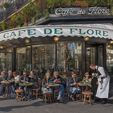 People having lunch, coffee, wine and beer at sidewalk tables outside the Café de Flore.
