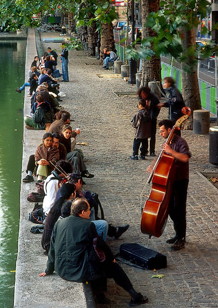 Trois musiciens en train de jouer sur le quai de Jemmapes du canal Saint-Martin.