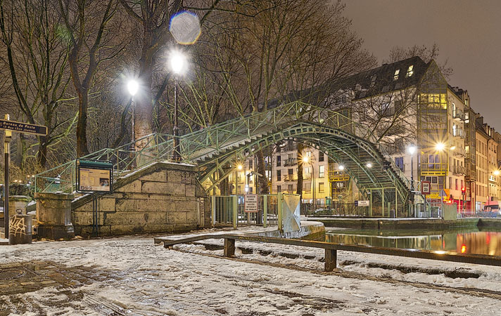 Passerelle de la Douane, a bridge over canal Saint-Martin in a snowstorm.