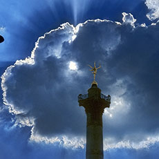 La colonne de Juillet devant le soleil caché par des nuages.