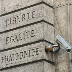 A surveillance camera on the façade of the Crédit Municipal bank next to the motto of the French Republic: “Liberty, Equality, Fraternity”.