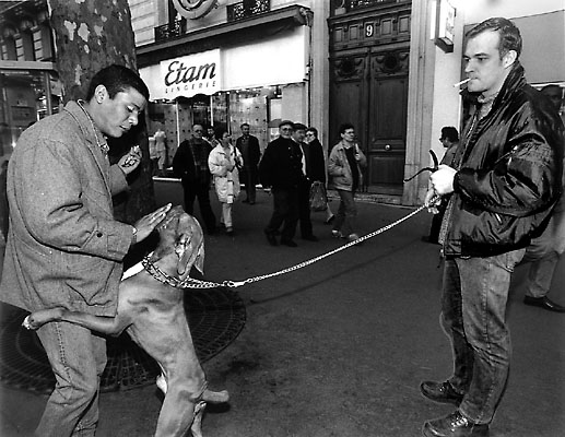 Two men with a dog on a leash in place de la République.