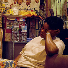 Une femme en train de dormir dans un restaurant africain sur la rue Bichat.