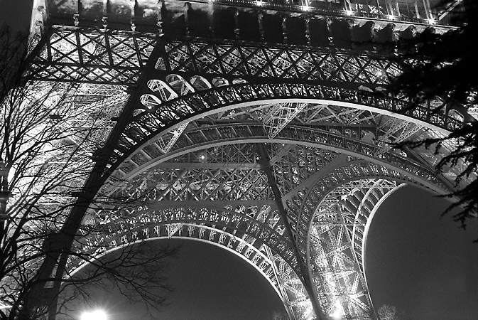 The lower portion of the north side of the Eiffel Tower at night.