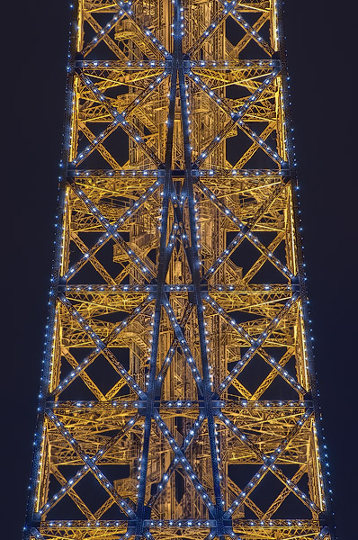 Des lumières clignotantes sur la tour Eiffel le soir.