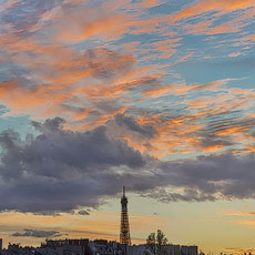 Des nuages roses et orange au-dessus de la tour Eiffel au coucher du soleil.