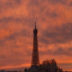 The Eiffel Tower and two streetlamps in the Tuileries Garden at sunset.