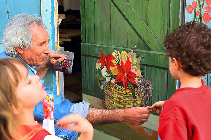 Un artiste avec des enfants devant son studio sur la rue Saint-Marthe.