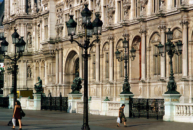Two women walking in front of l’Hôtel de Ville.