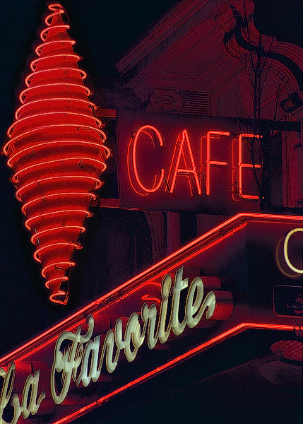 A neon tobacconist sign on boulevard Saint-Michel at night.