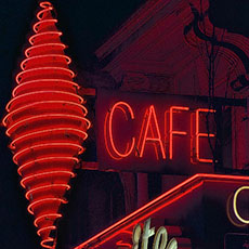 A neon tobacconist sign on boulevard Saint-Michel at night.