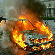 Une voiture en feu à côte du musée du Louvre.