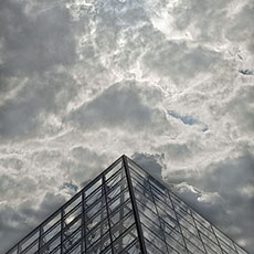 La Grande Pyramide du musée du Louvre devant des nuages.