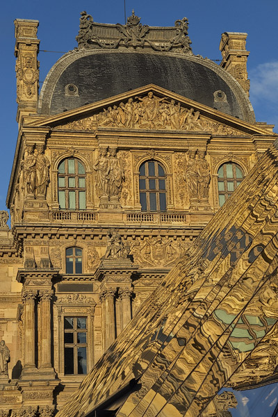 Le pavillon Richelieu du musée du Louvre reflété dans la pyramide de verre du musée au coucher du soleil.