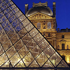 The Louvre’s Glass Pyramid and the pavillon Denon behind at night.