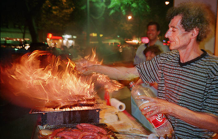 A street vendor selling merguez sausages on boulevard Saint-Germain at night.