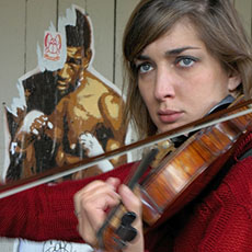 Une jeune femme joue du violon dans la place des Vosges.