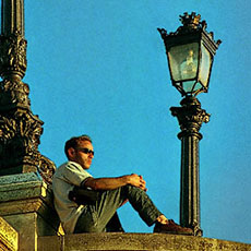 A young man watching the sun set from pont Neuf.