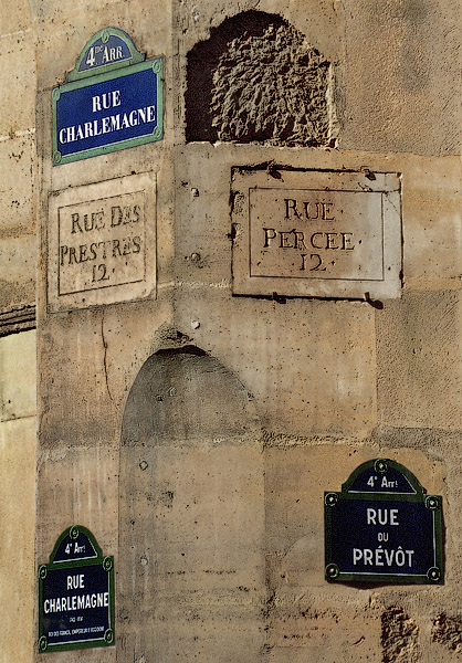 Five street signs at the corner of rue Charlemagne and rue du Prévôt.