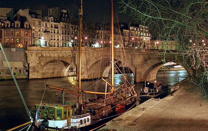 Boats on the Left Bank next to pont Neuf at night.